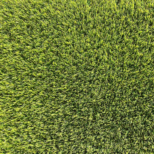 Gros plan d’une pelouse verte dense et bien entretenue, montrant une vue aérienne uniforme des brins d’herbe.