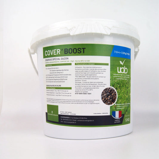 Un seau blanc de 5 kg de "Cover'Boost", un engrais spécial gazon à composition organo-minérale NK + MgO (7-0-4 + 3.5 MgO MIN). L'étiquette verte et blanche présente les caractéristiques du produit, les dosages d'utilisation, ainsi que des recommandations spécifiques. Le produit est fabriqué en France et conçu pour enrichir les sols tout en respectant les normes d'agriculture biologique. Une illustration de granulés et une pelouse verte accompagnent les informations.