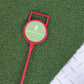 Marqueur de golf rouge avec poignée, portant le logo 'COVERGARDEN GOLF', posé sur une surface de gazon synthétique vert.